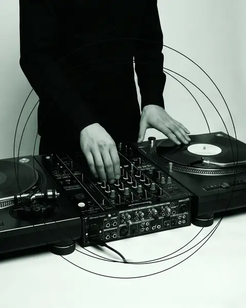 Close-up of a DJ's hands on two turntables and a mixer